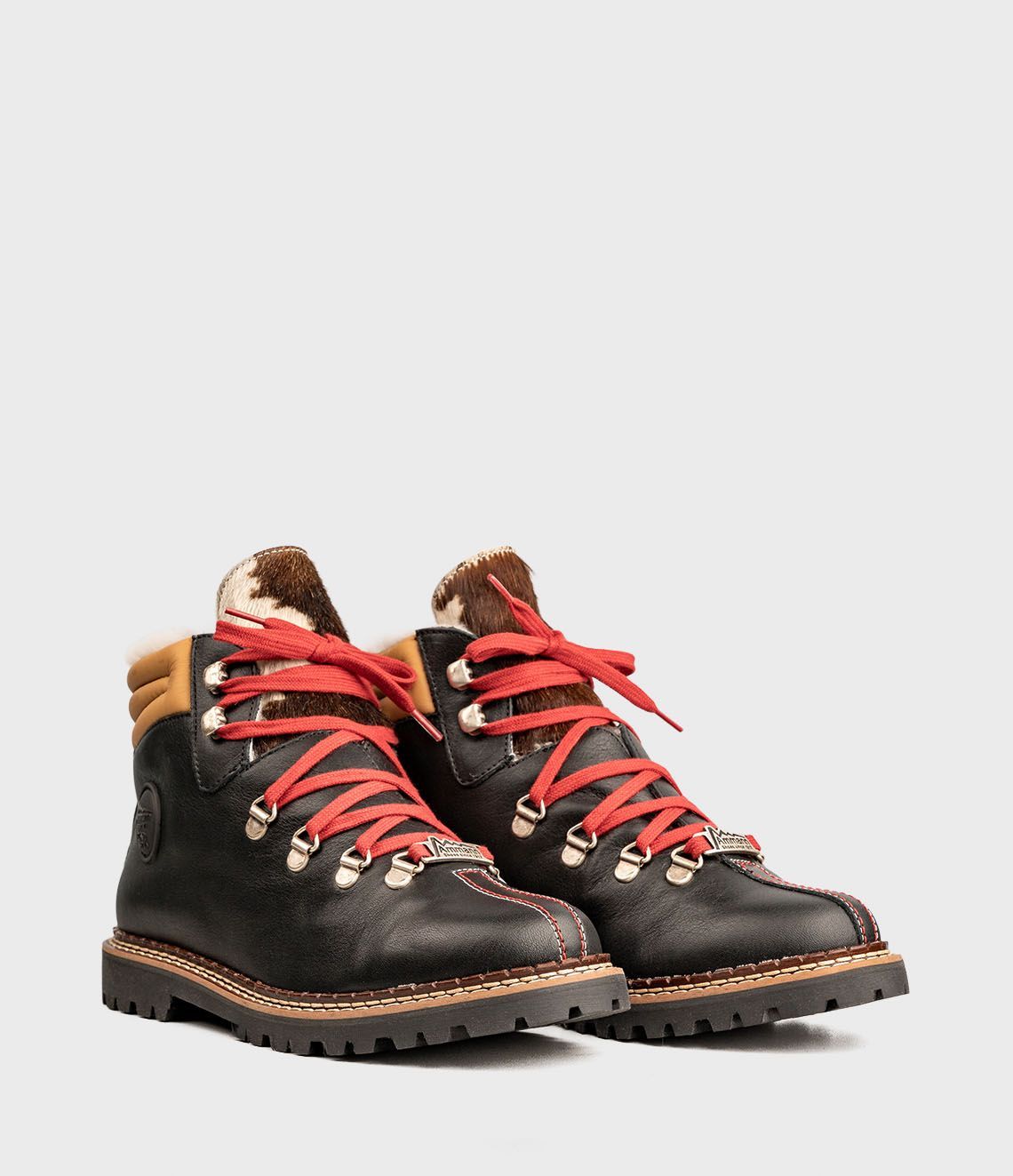 Bottes de randonnée noires avec lacets rouges, accents dorés et doublure en fausse fourrure.
