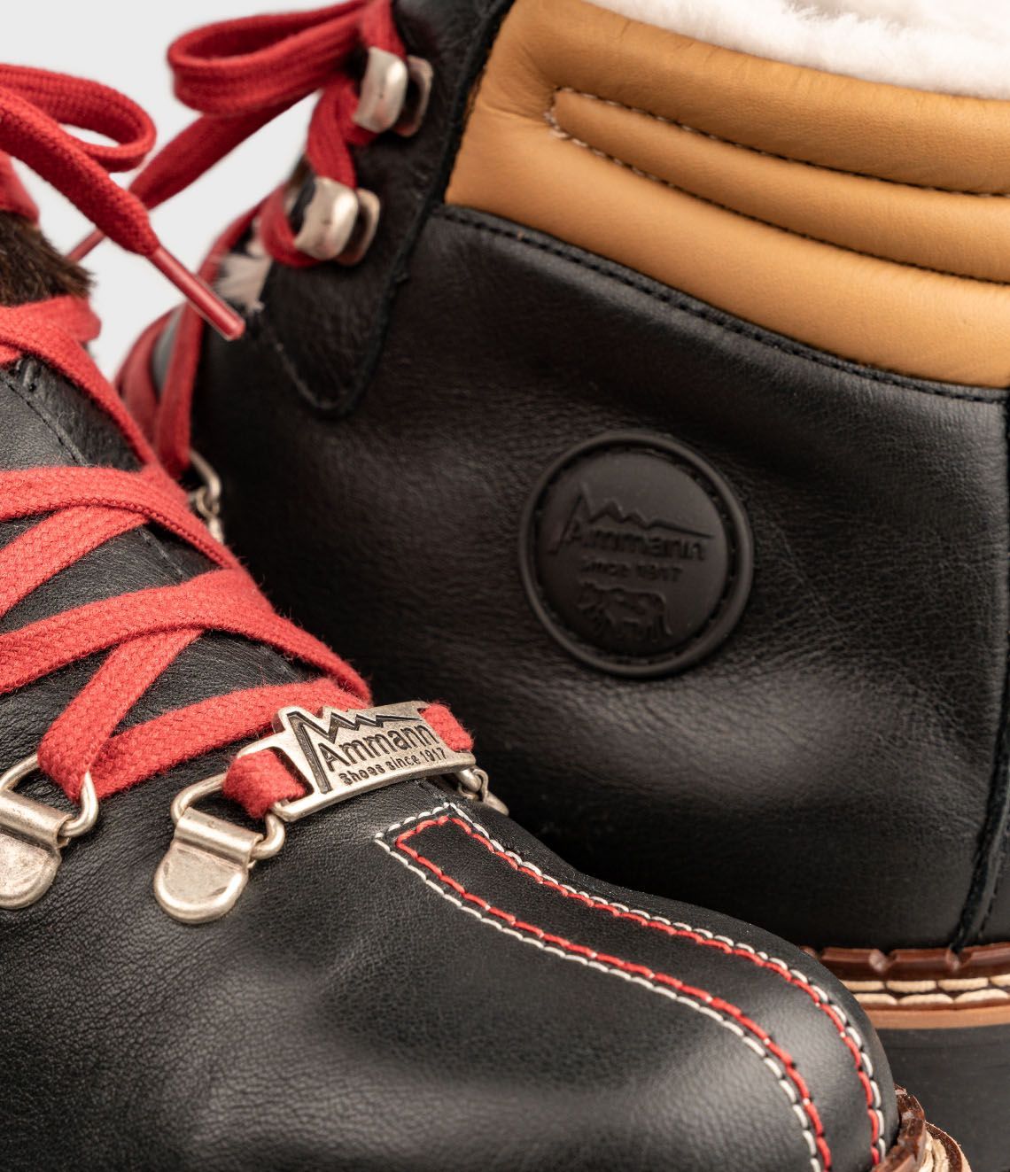 Bottes de randonnée noires avec lacets rouges, accents dorés et doublure en fausse fourrure.