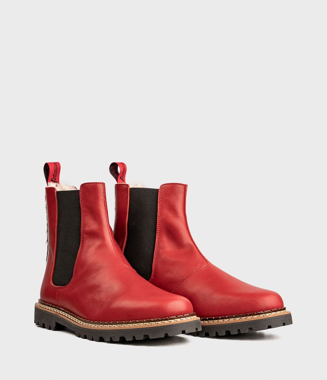 Bottines Chelsea en cuir rouge avec empiècements latéraux élastiques noirs et semelles crantées.