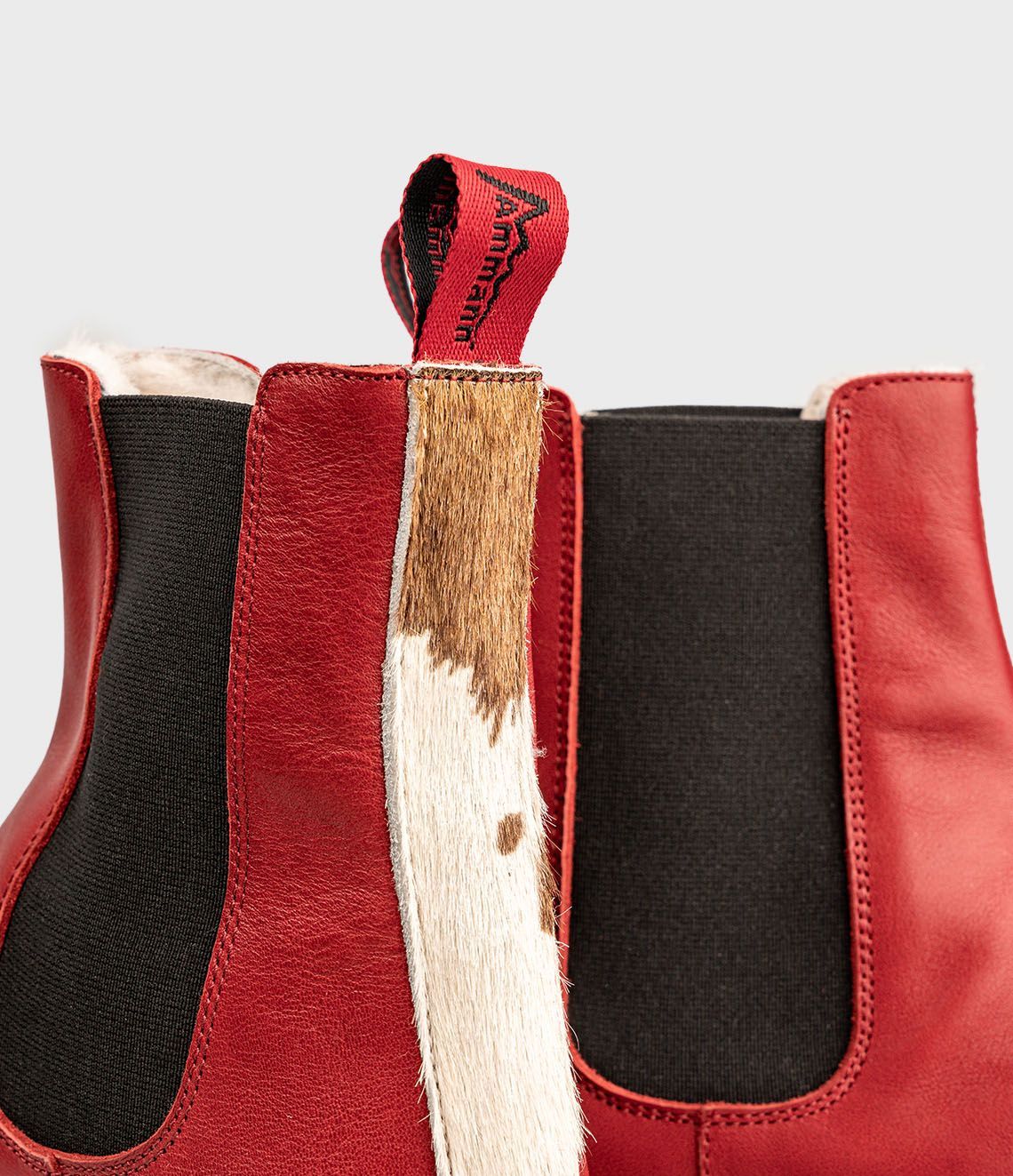 Bottines Chelsea en cuir rouge avec empiècements latéraux élastiques noirs et semelles crantées.
