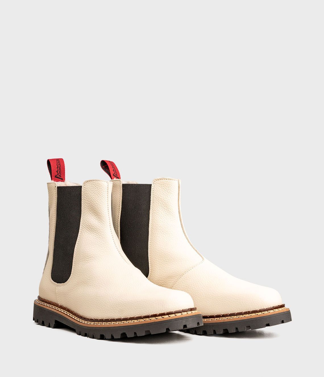 Paire de bottines Chelsea en cuir blanc cassé avec empiècements latéraux élastiques noirs.