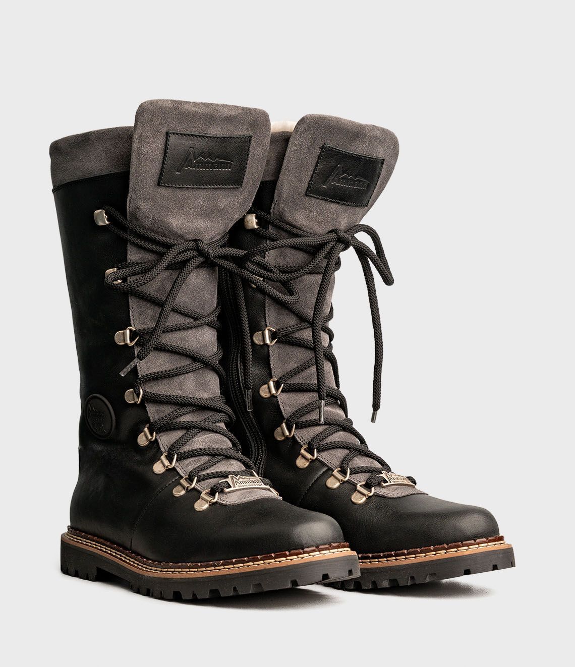 Bottes d'hiver noires et grises avec lacets épais et semelles crantées.