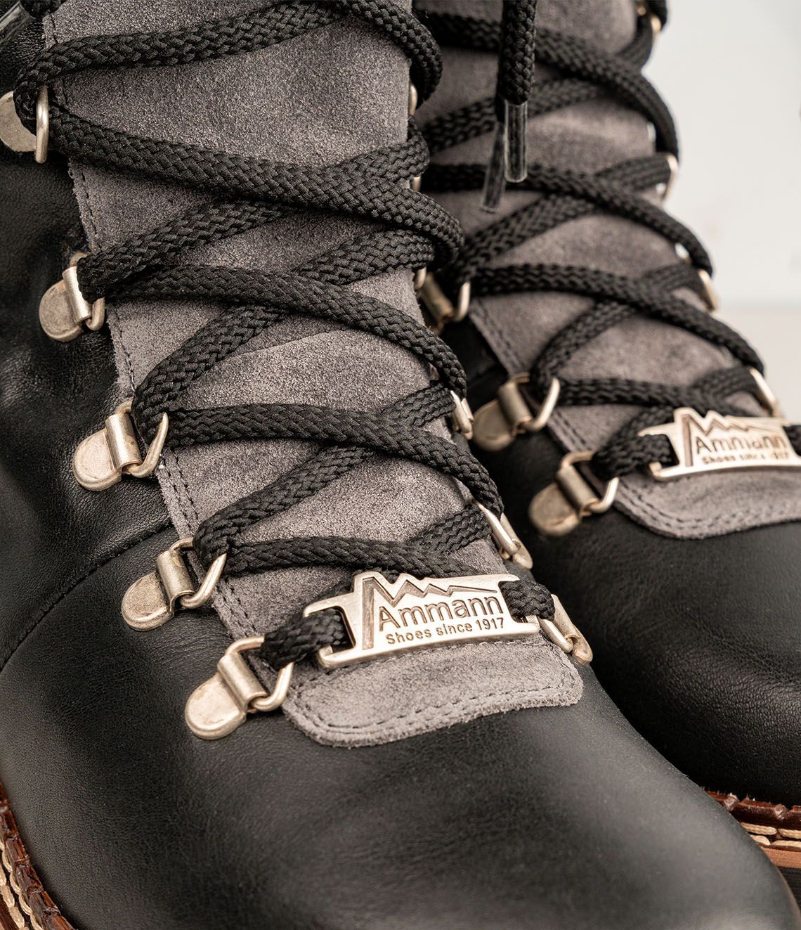 Bottes d'hiver noires et grises avec lacets épais et semelles crantées.