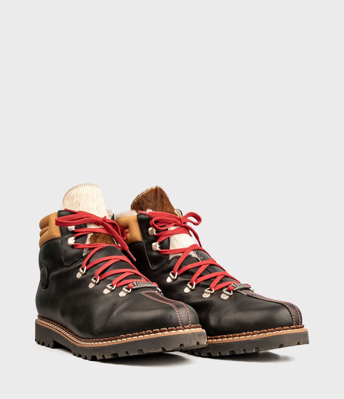 Bottes de randonnée en cuir noir avec lacets rouges.