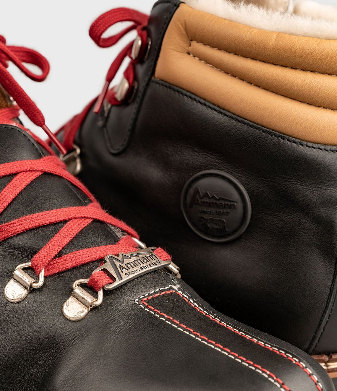 Bottes de randonnée en cuir noir avec lacets rouges.