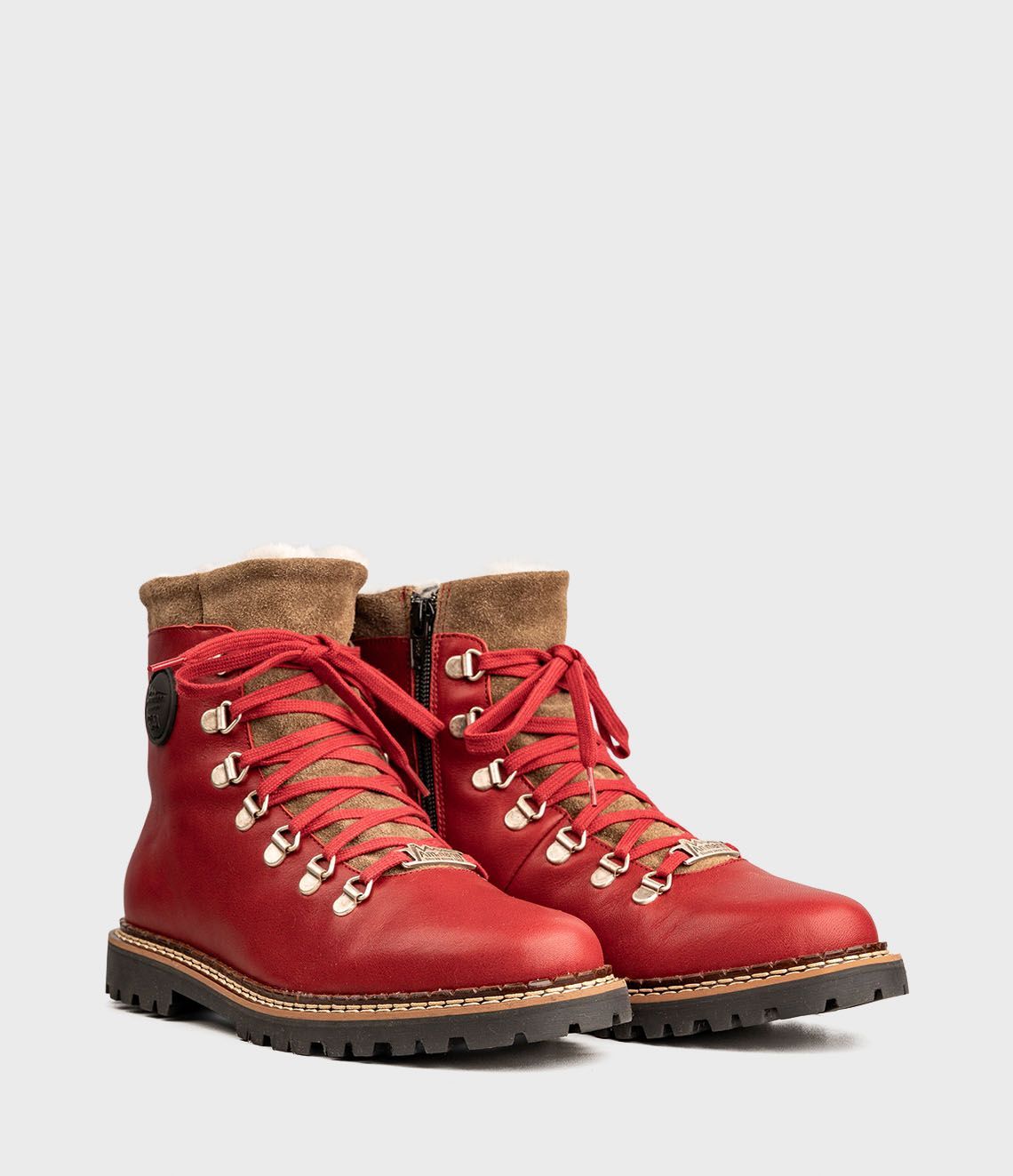 Bottes de randonnée rouges avec bordure et lacets marron.