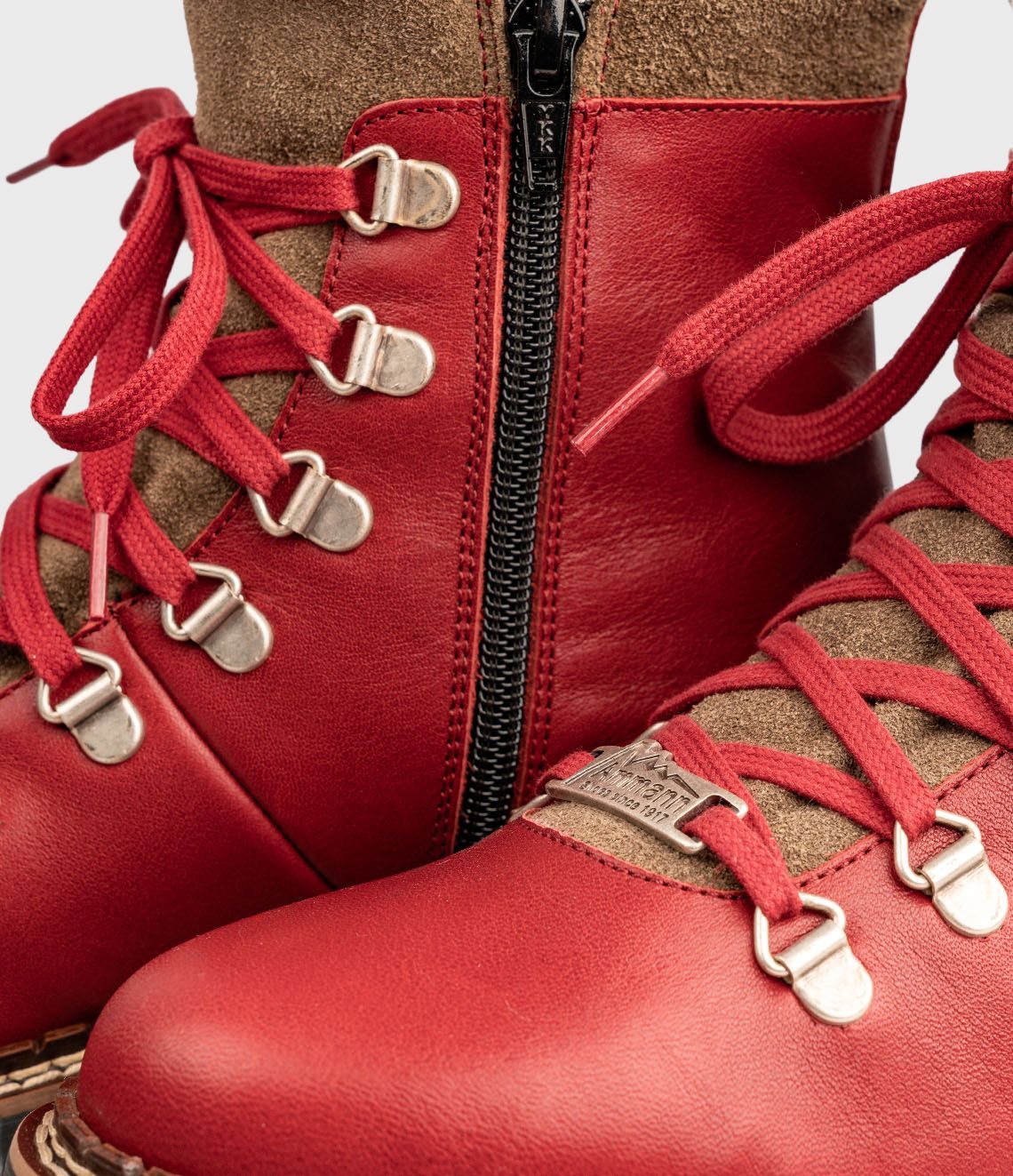 Bottes de randonnée rouges avec bordure et lacets marron.
