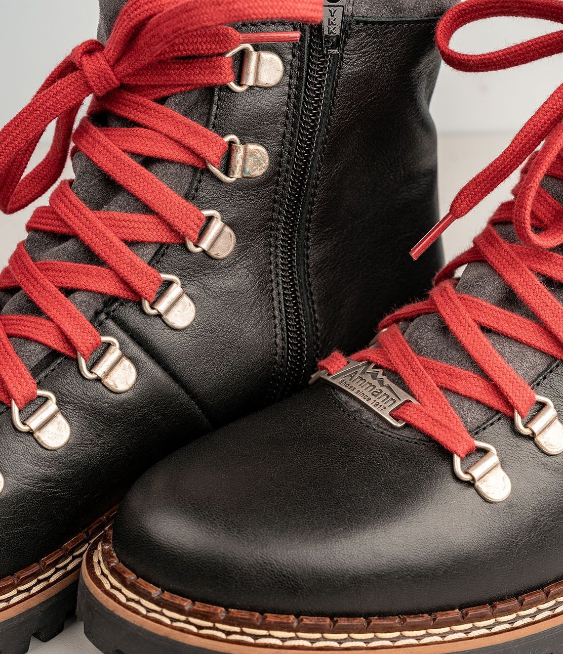 Bottes d'hiver en cuir noir avec lacets rouges et doublure en fourrure grise.