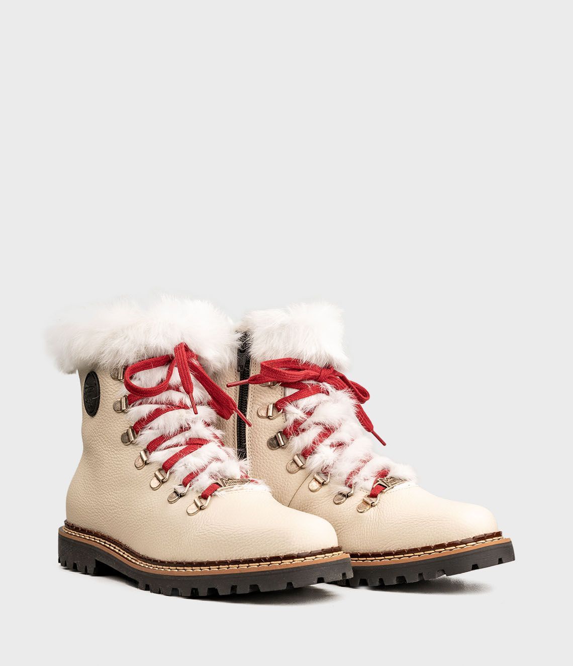 Bottes d'hiver de couleur crème avec lacets rouges, bordure en fourrure et semelle robuste.