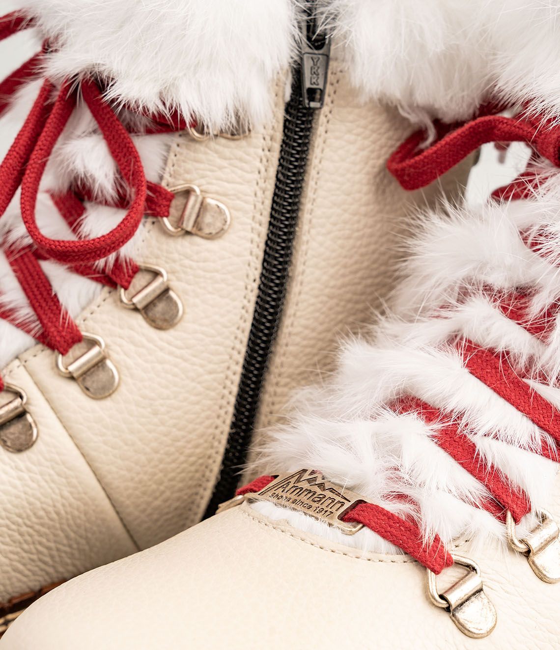 Bottes d'hiver de couleur crème avec lacets rouges, bordure en fourrure et semelle robuste.