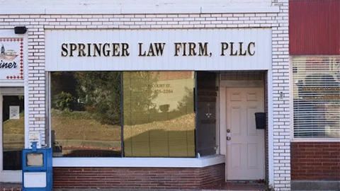Storefront with sign reading “Springer Law Firm, PLLC” on a brick building.