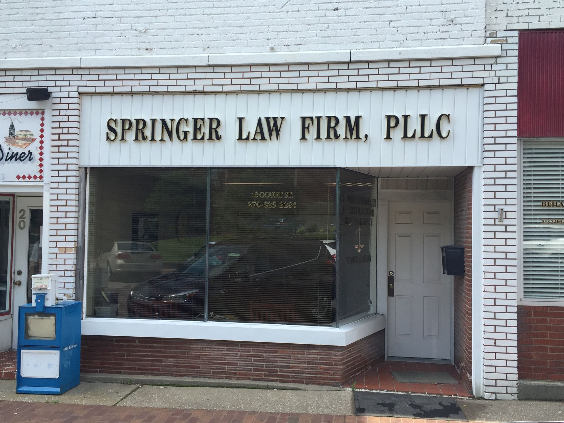 Springer Law Firm, PLLC storefront with white brick facade and large front window
