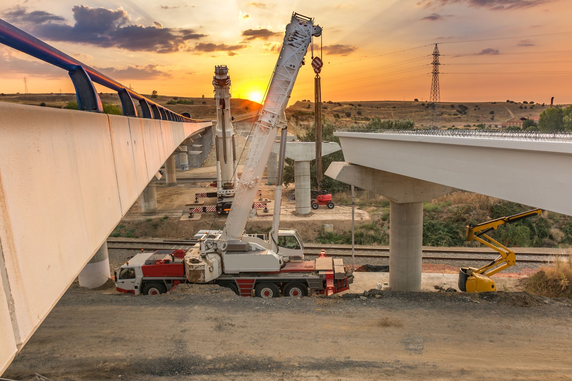 Bridge construction site with cranes at sunrise