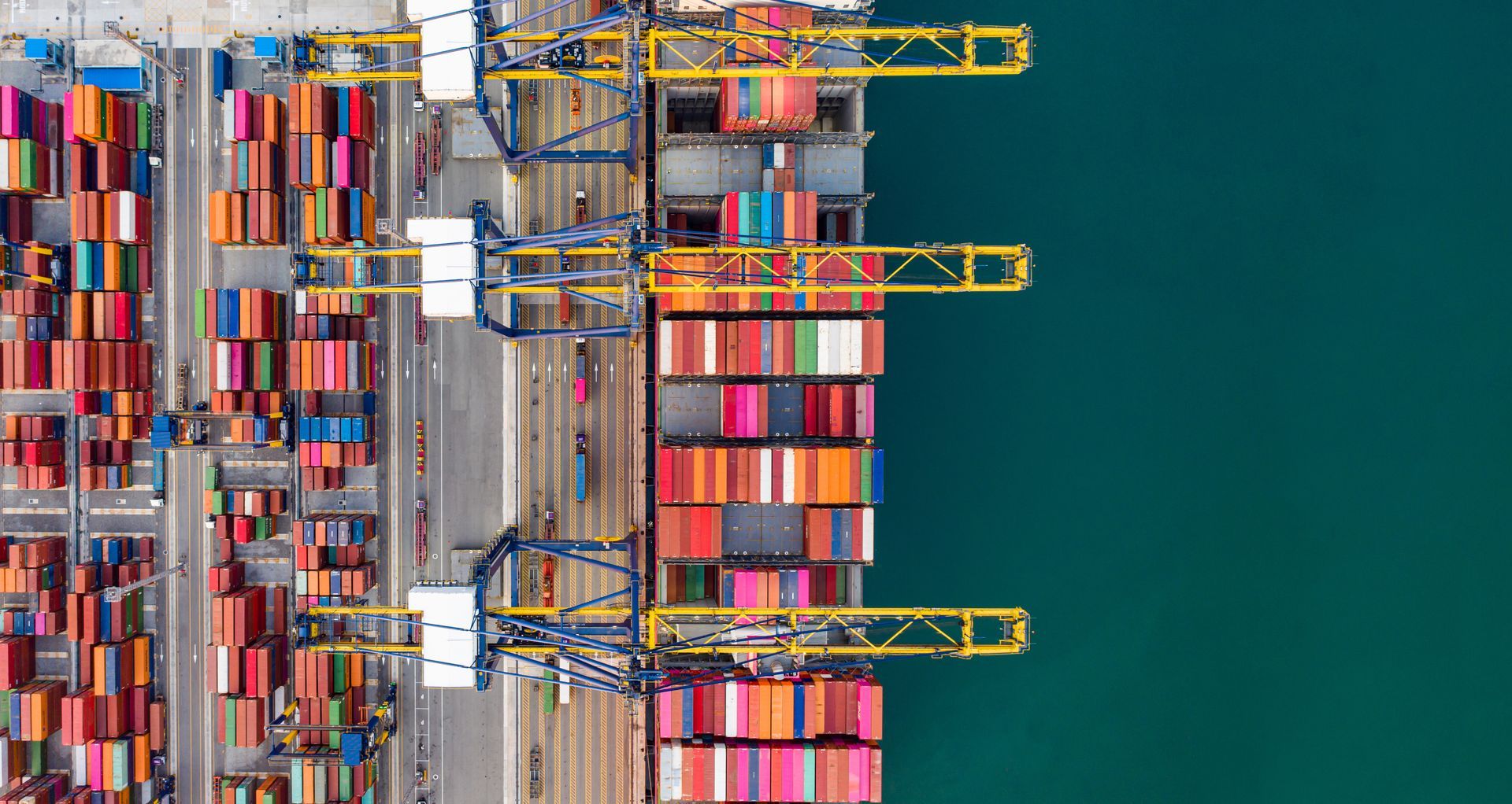 Aerial view of colourful shipping containers and port cranes