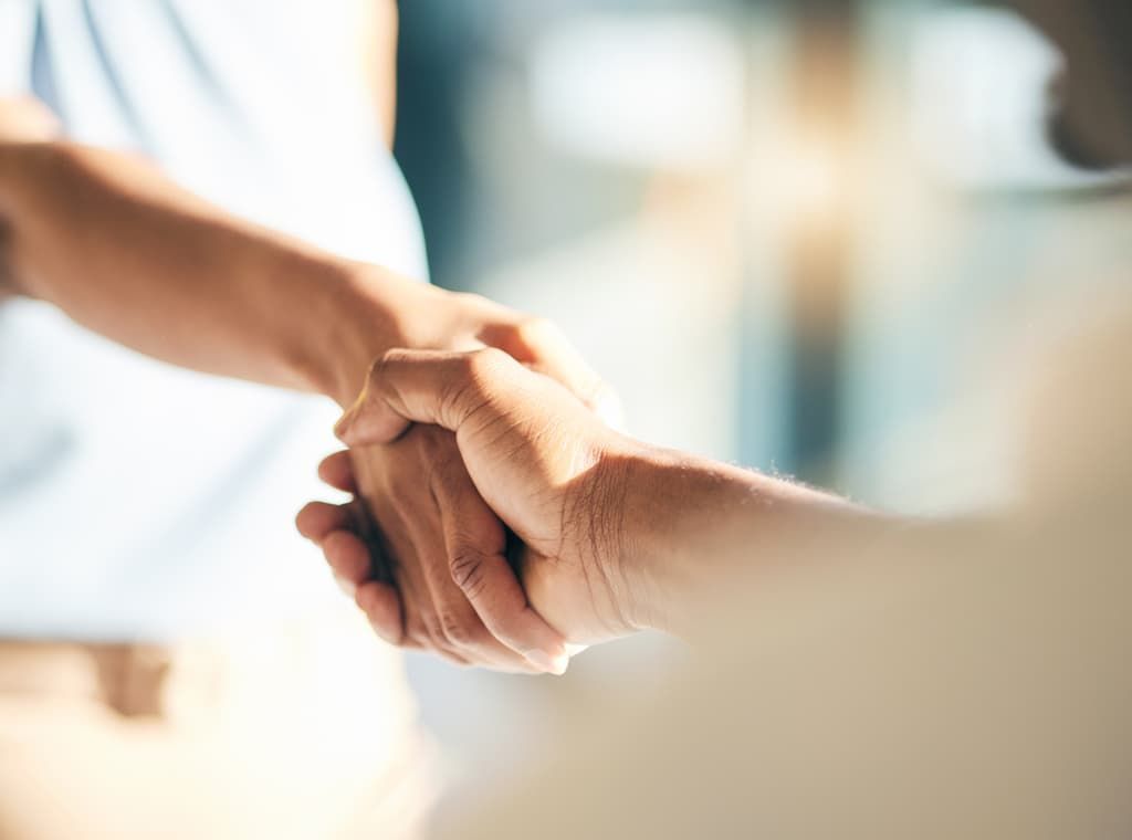 Close-up of two people shaking hands in a business setting