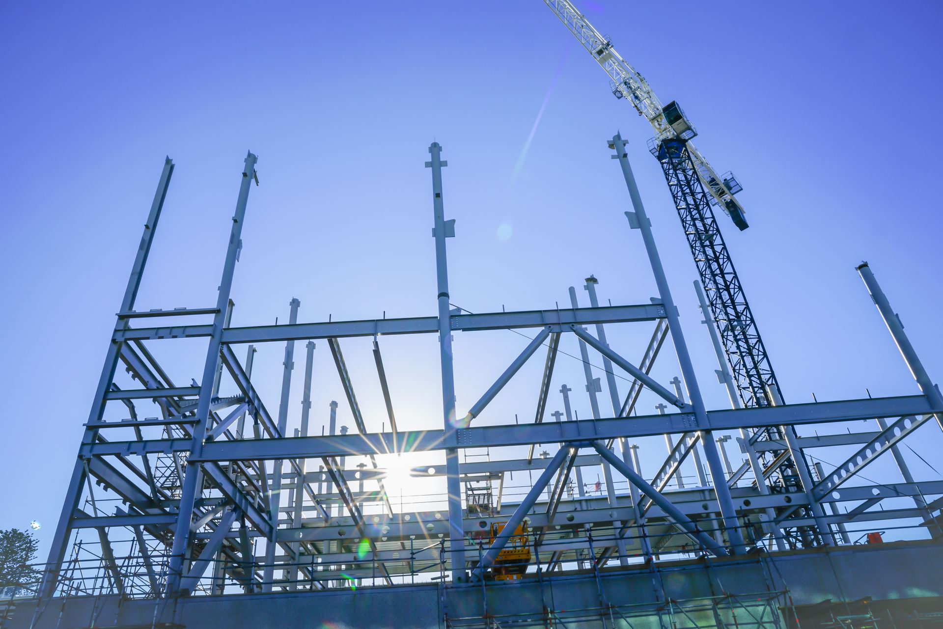 Steel building framework under construction with cranes