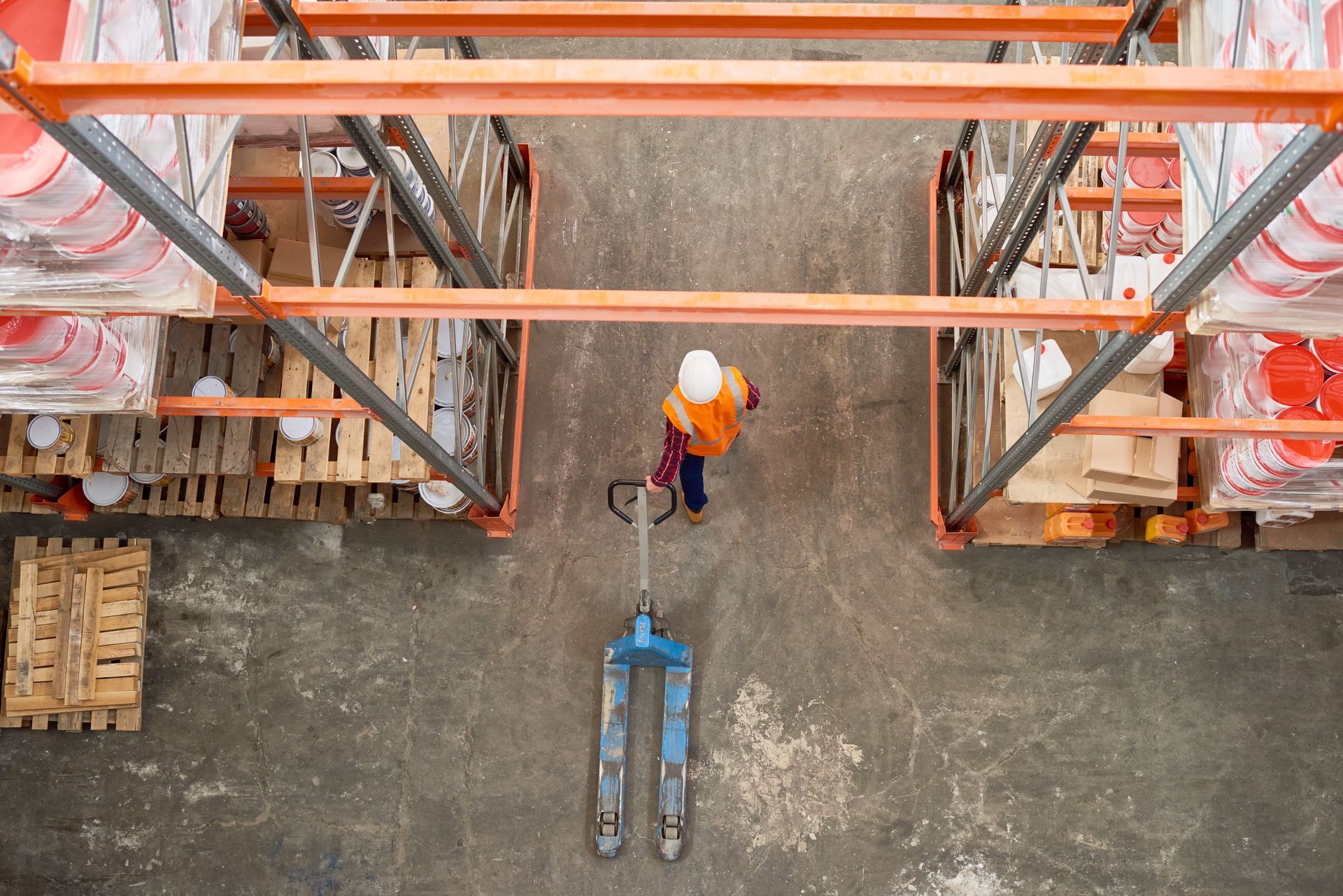 Worker operating pallet jack in warehouse