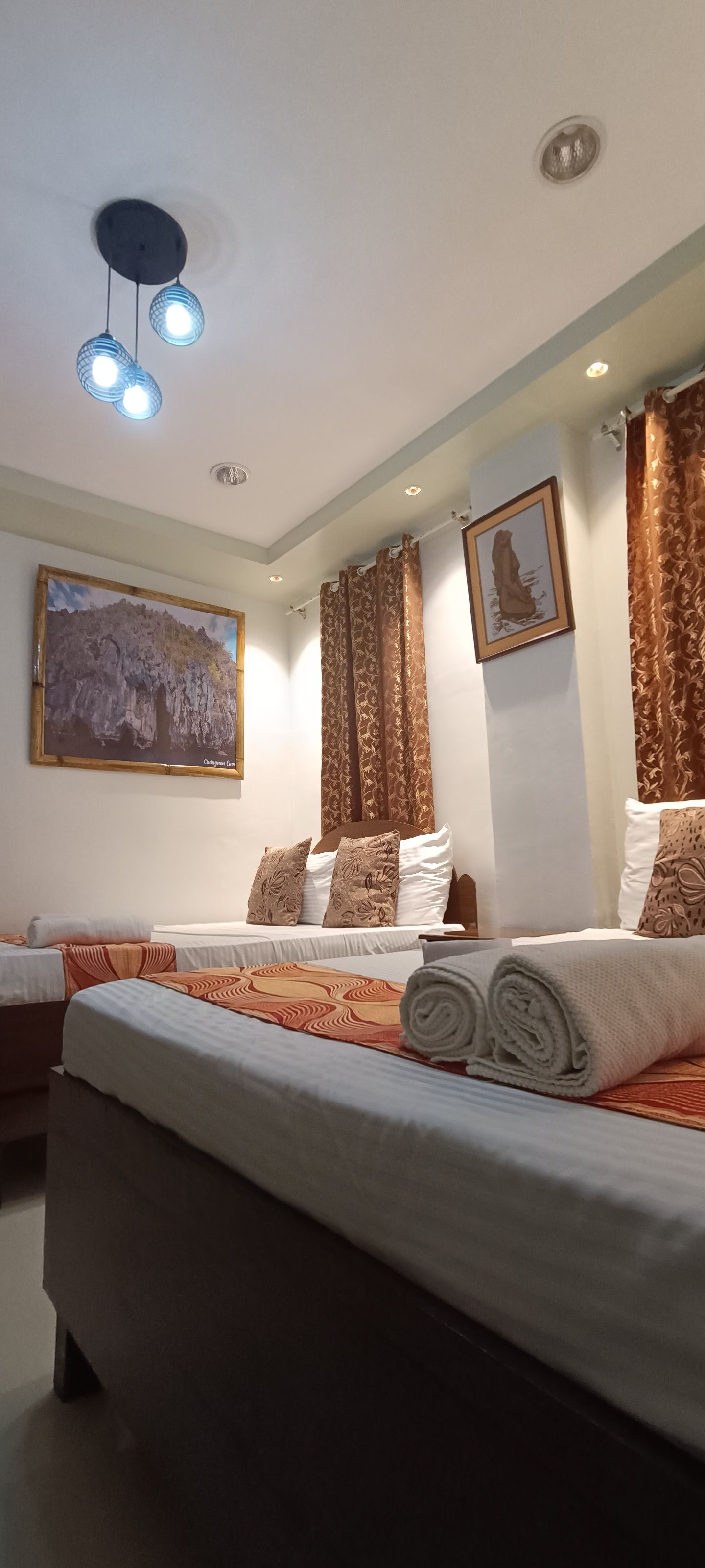 A hotel room with three beds and a couch.