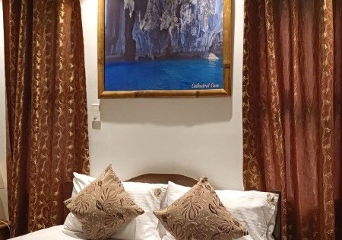 There is a painting on the wall above the bed.