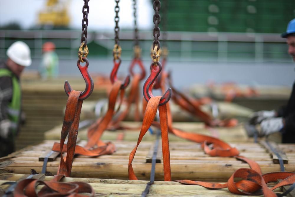 A Bunch of Slings Are Hanging from Chains on A Wooden Table — Budget Timbers in North Lismore, NSW