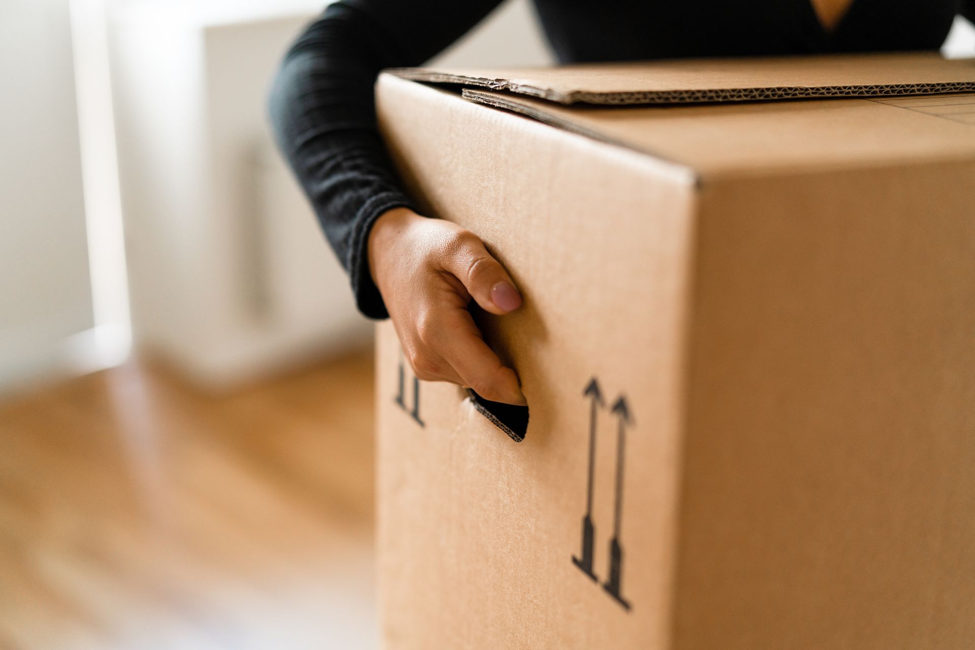 A person is holding a cardboard box in their hand.