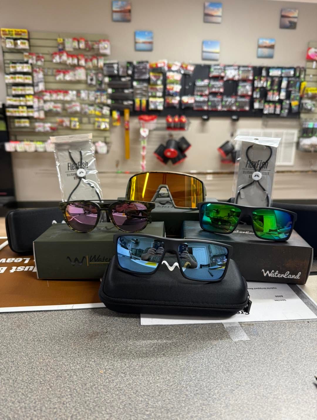 Sunglasses displayed on cases in a store, with colorful mirrored lenses on a counter.