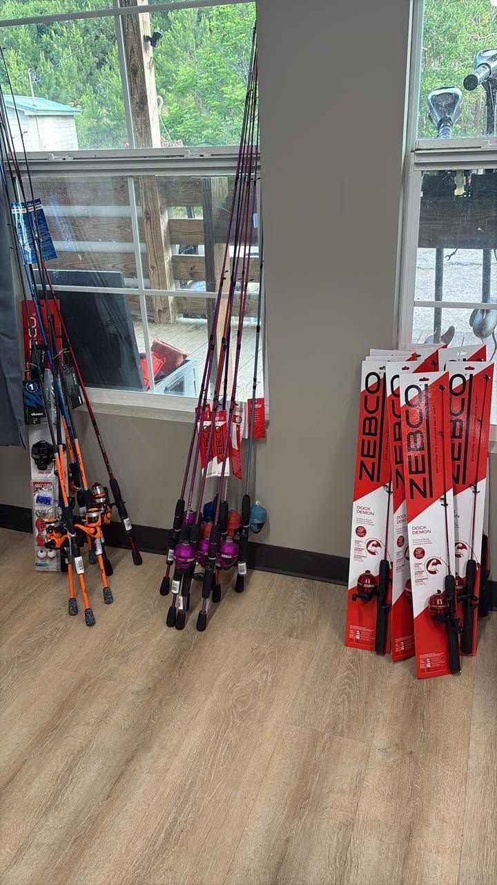 Racks of colorful skis and poles displayed by large windows in a store.