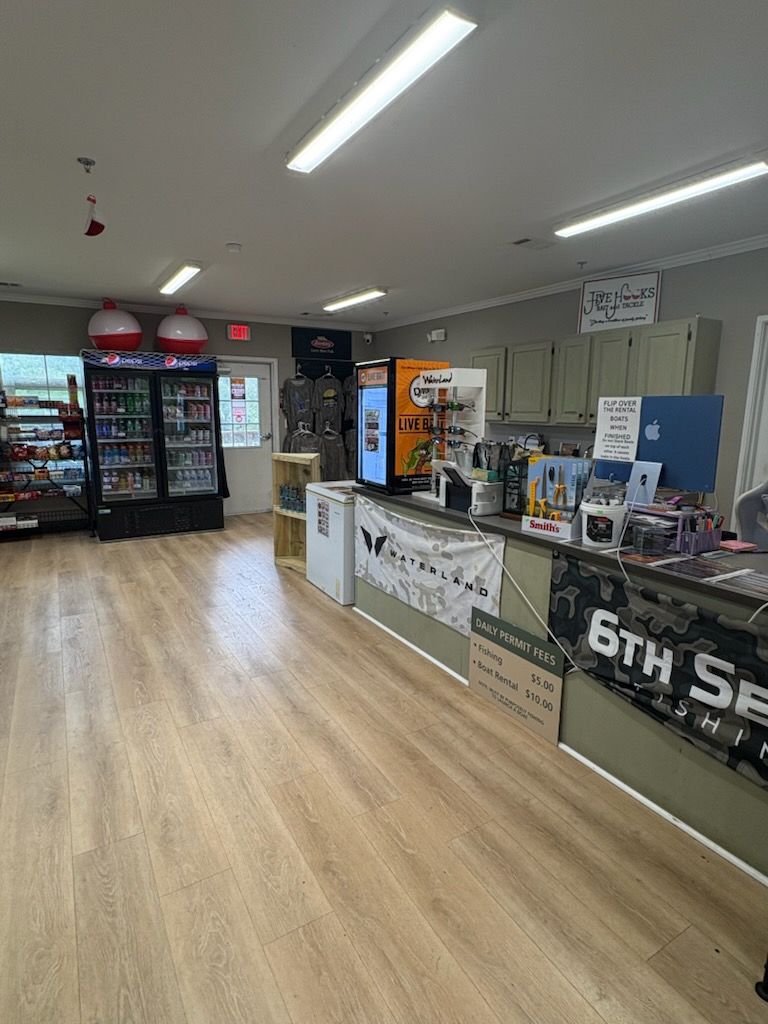 Convenience store interior with refrigerated drinks, checkout counter, and bright overhead lights