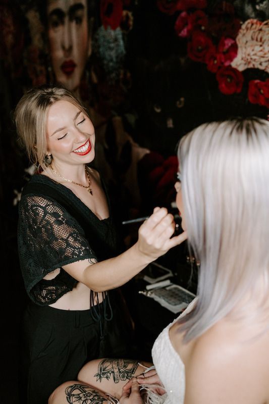 A woman is applying makeup to another woman 's face.