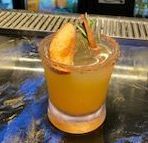 A close up of a drink in a glass on a table.