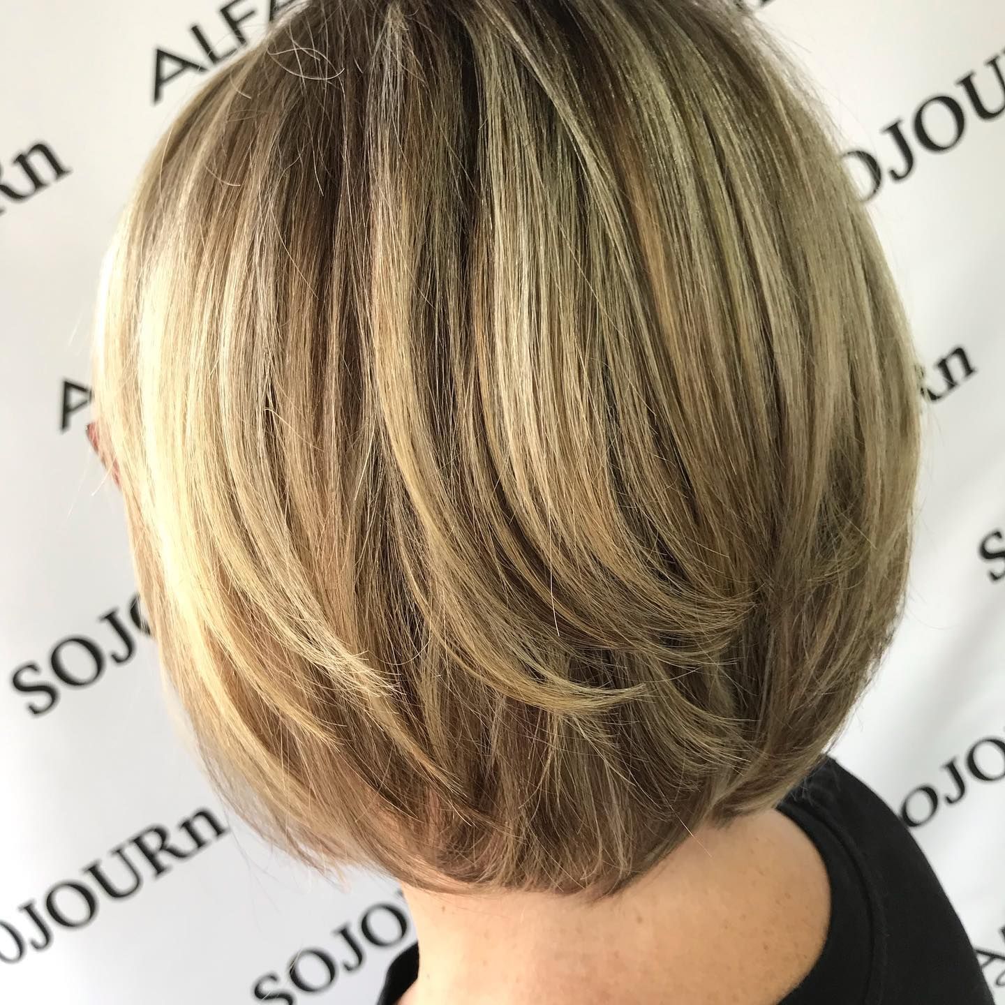 A woman 's hair is shown in front of a sign that says sojourn