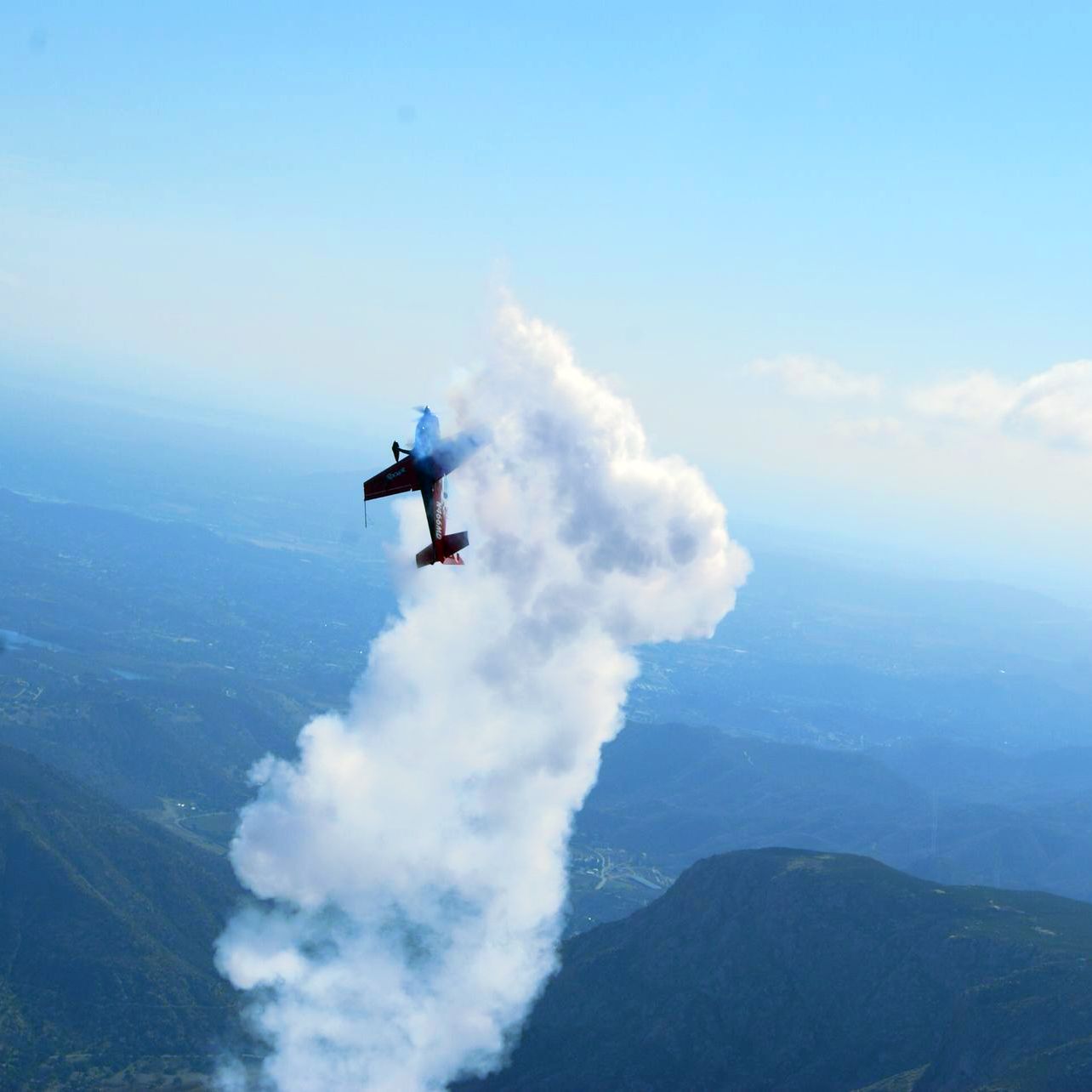 A plane is flying through the air with smoke coming out of it