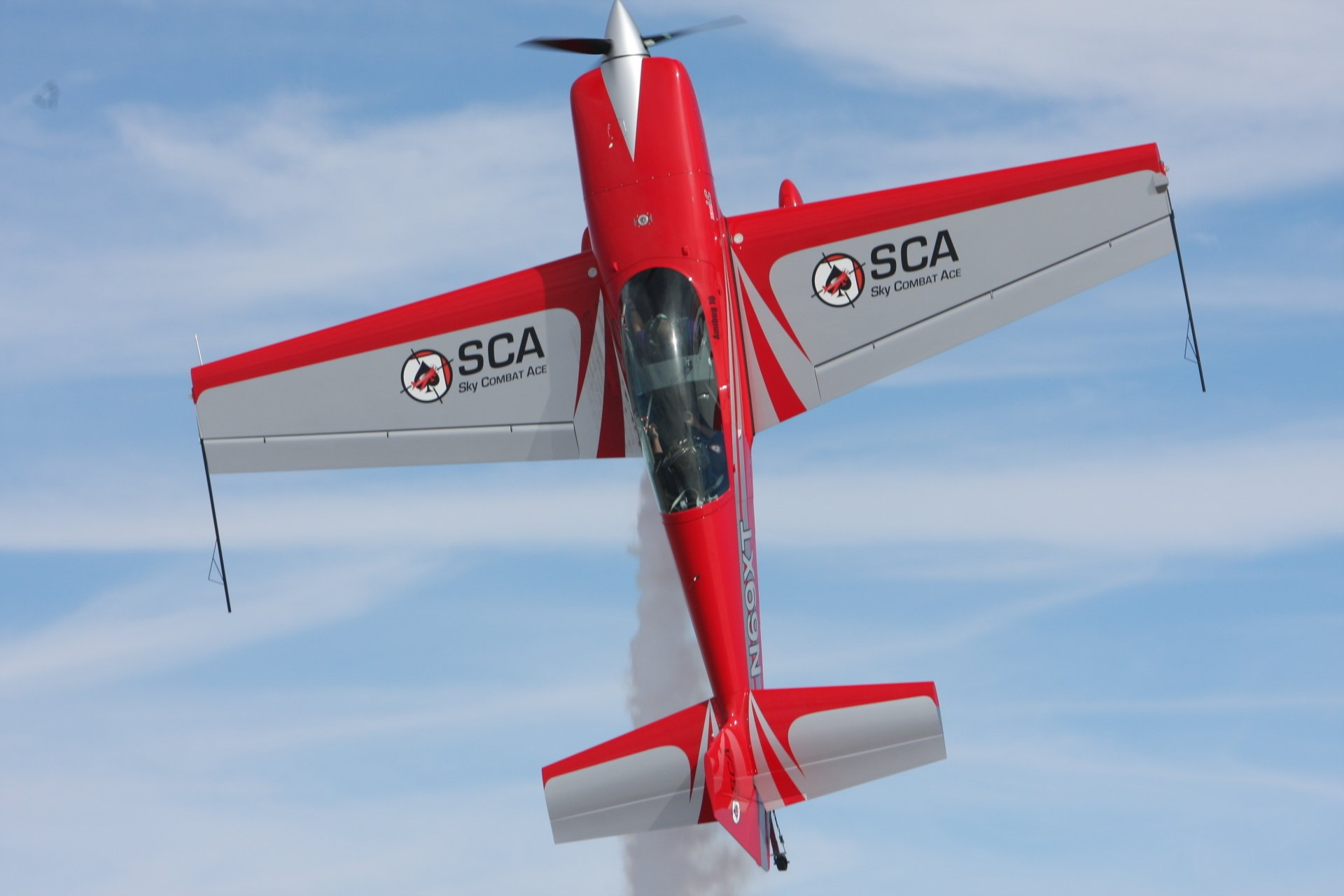 A red and gray airplane with sca written on the wing