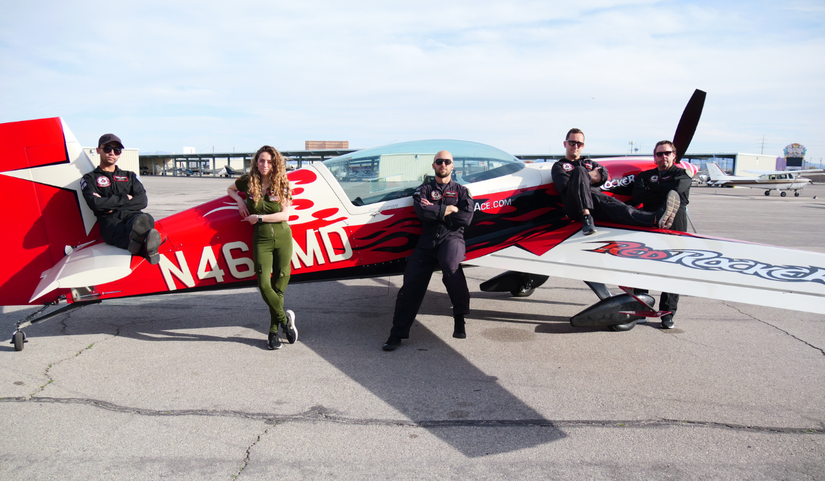 A group of people are standing in front of a small plane with the letters n461md on it.