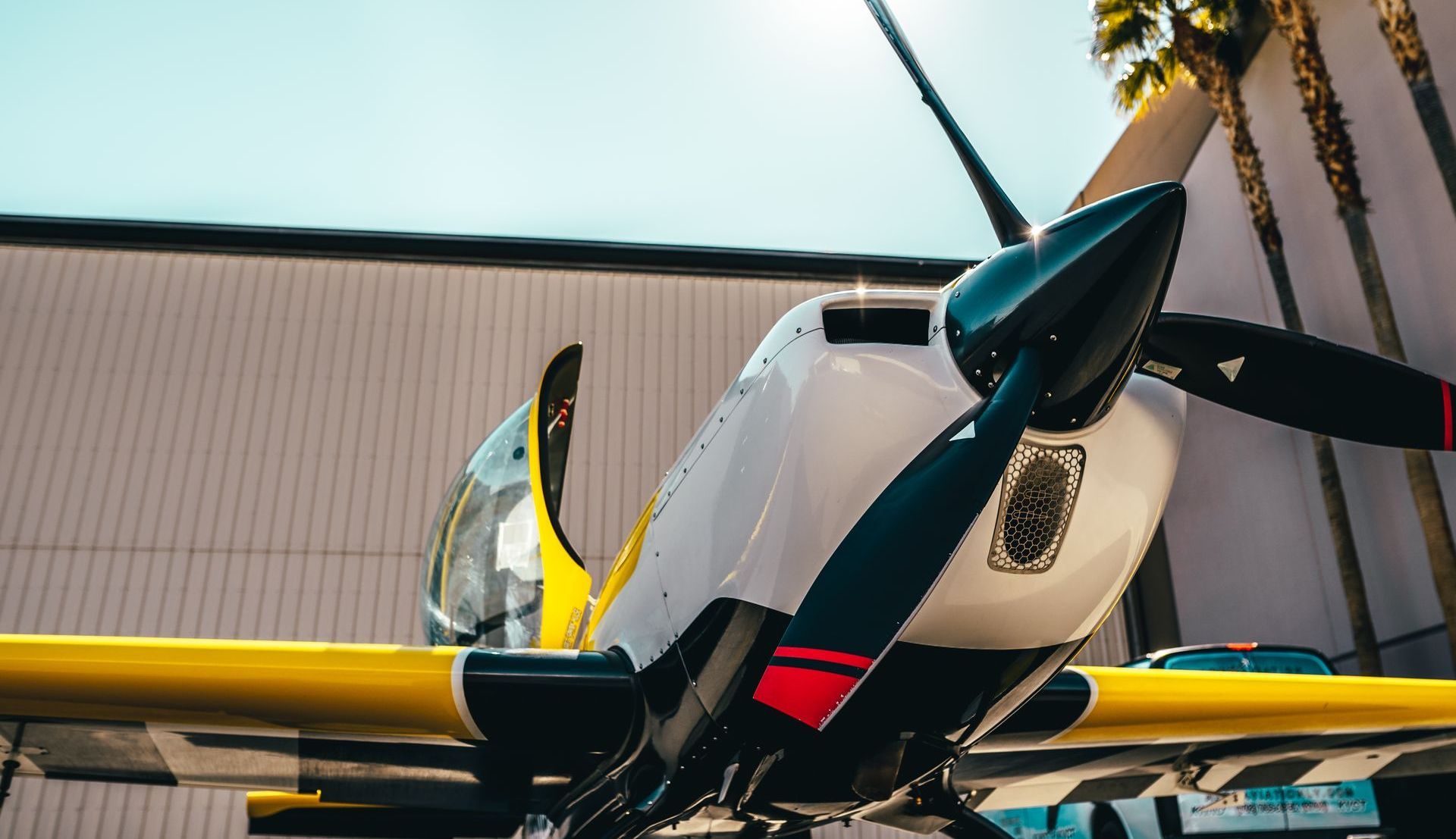 A small propeller plane is parked in front of a building.