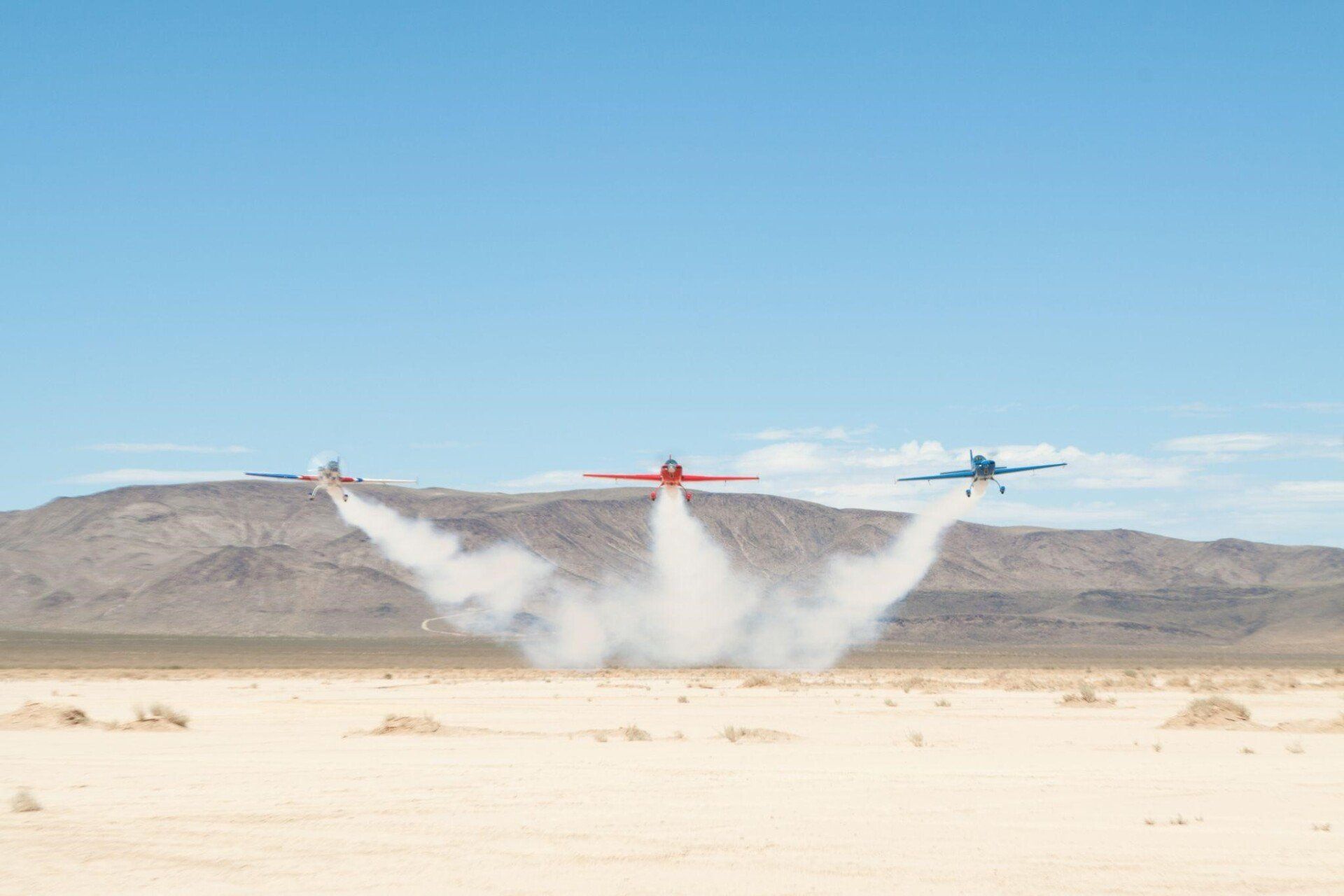 3 sky combat ace stunt planes flying side by side