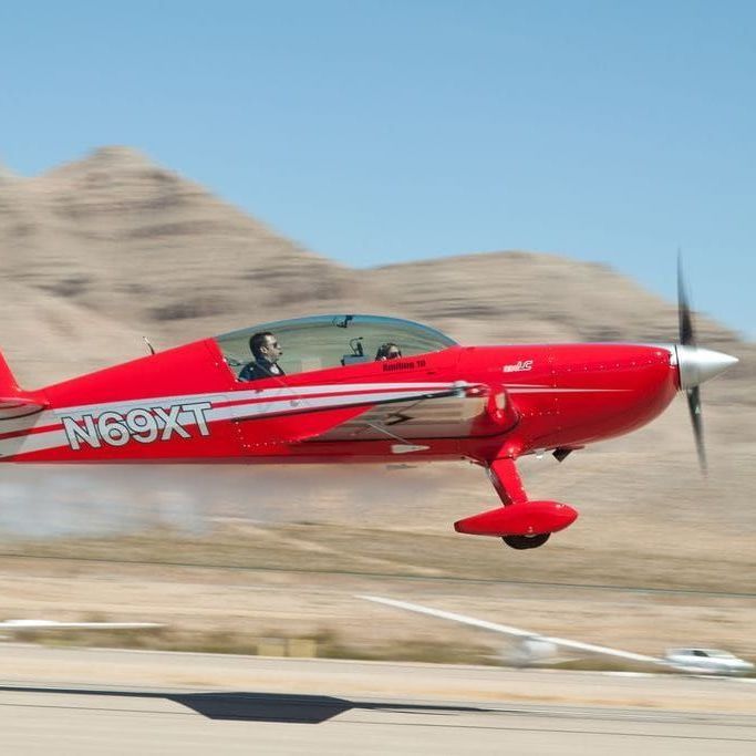 A small red airplane with ng9xt written on the side
