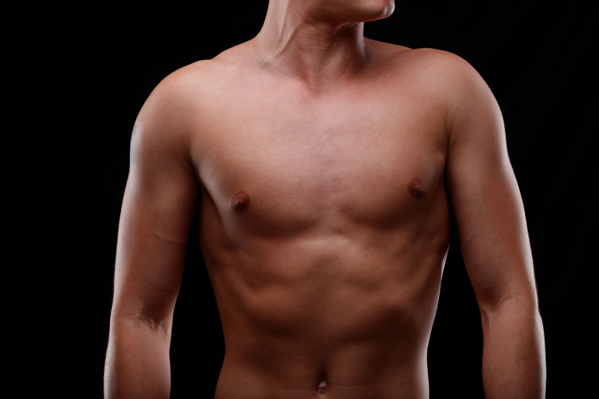 Person's chest being waxed by gloved hands. Wax is applied to chest.
