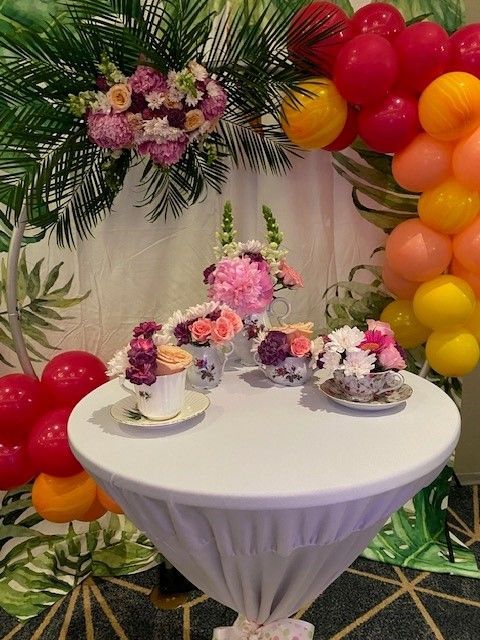 A decorated table with vintage china tea cups filled with fresh flowers. Create for a high tea setting.