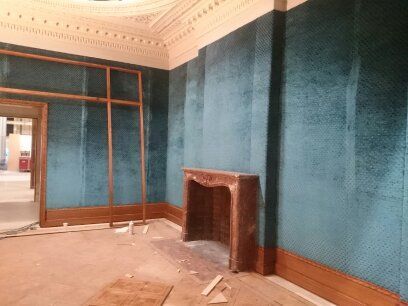 An empty old fashined room with walls lined with velvet. From