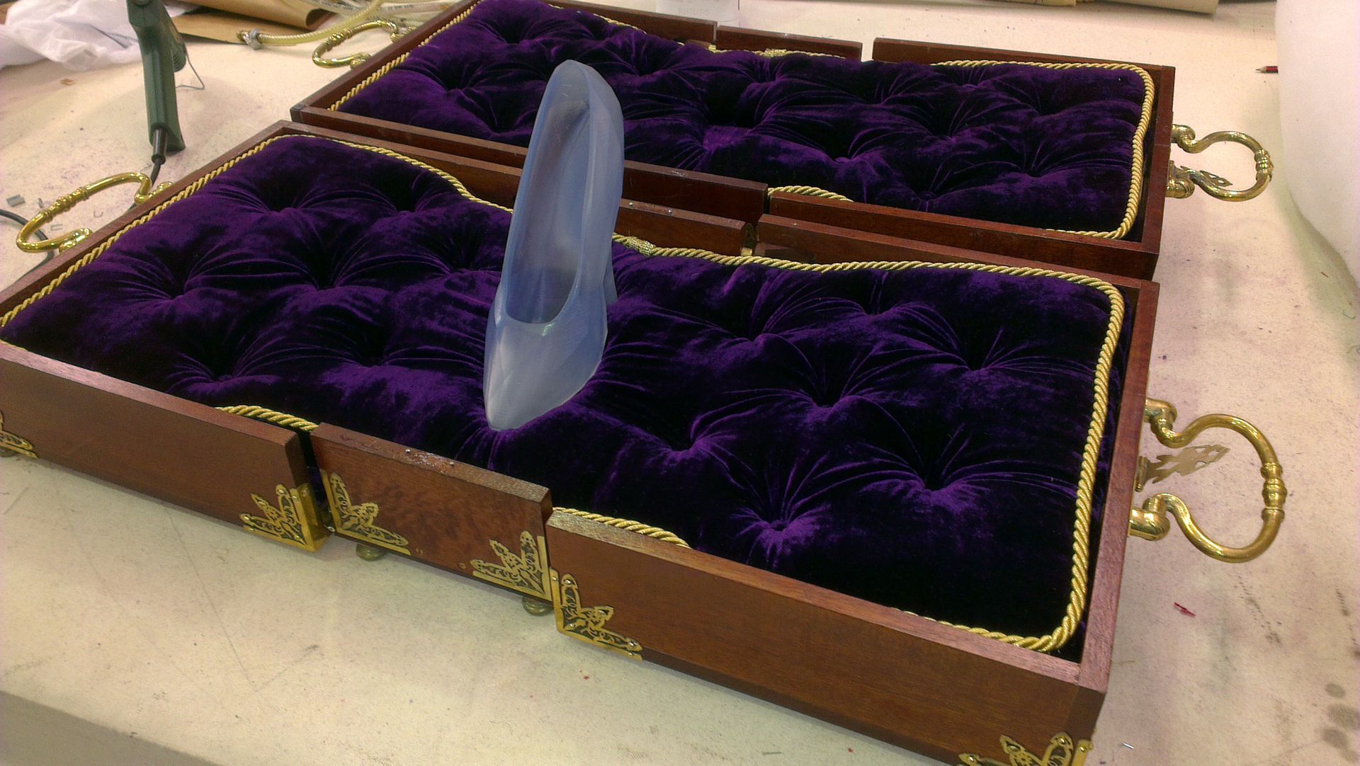A velvet lined box containing a mockup for the glass slipper from