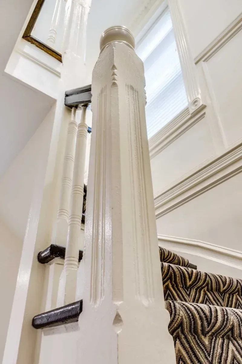 A staircase with a carpeted staircase and a white railing.