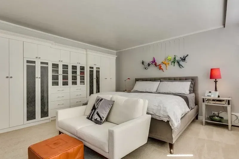 A bedroom with a bed , couch , and ottoman.