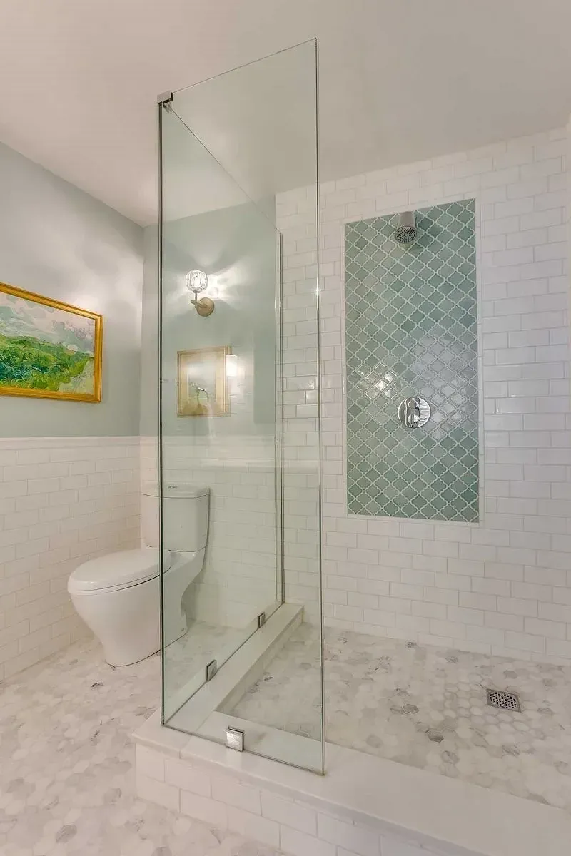 A bathroom with a walk in shower and a toilet.