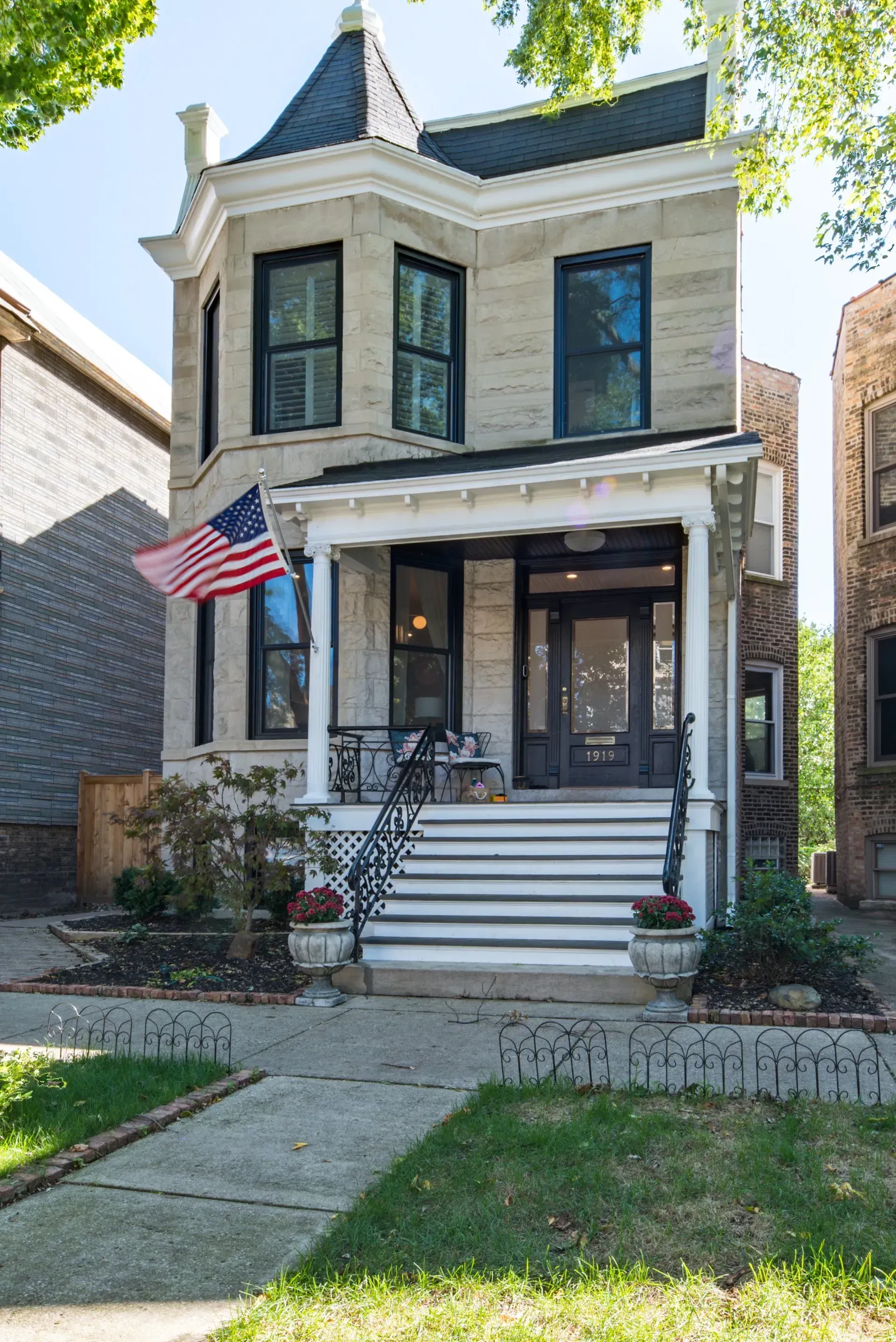 A house with an american flag on the front porch.