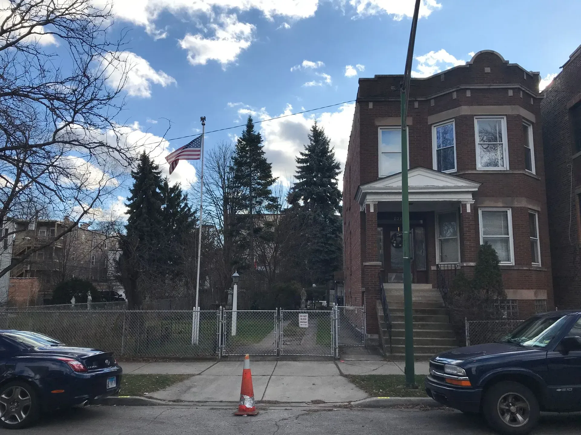 Cars are parked in front of a large brick building