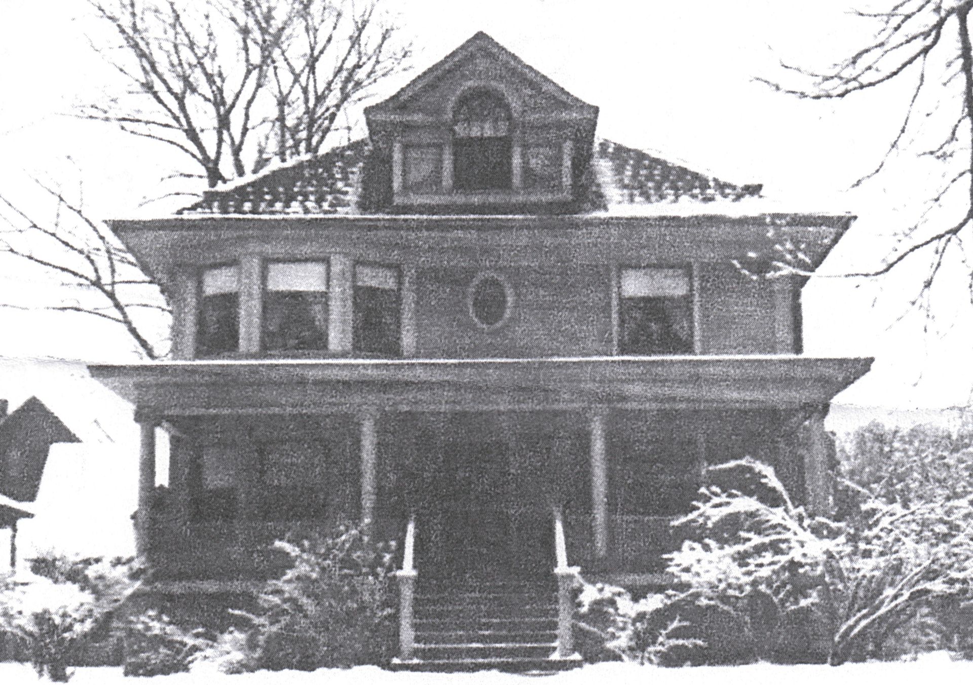 A black and white photo of a large brick house