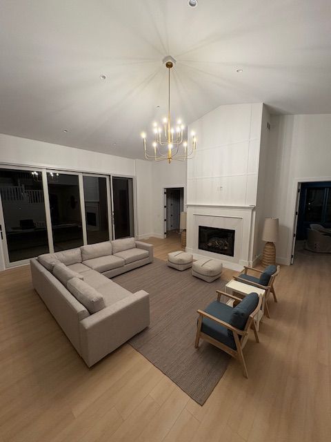 A living room with a couch , chairs , and a fireplace.