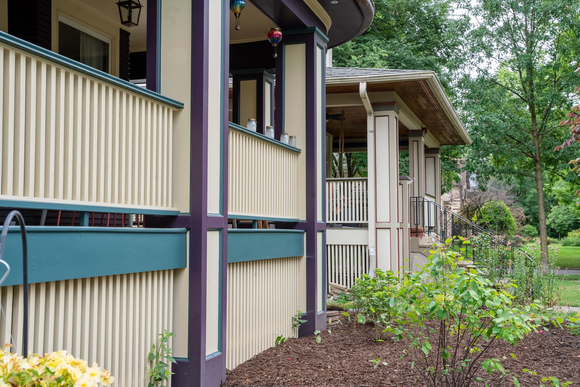 A house with a porch and a fence in front of it.