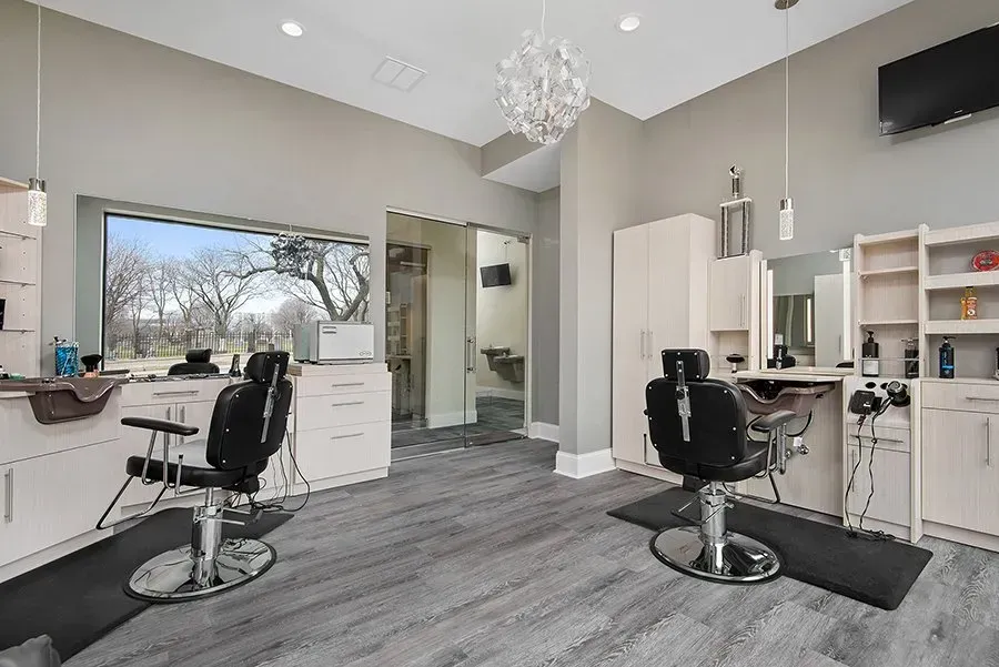 A barber shop with two chairs and a large window.